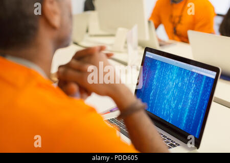 Hacker at laptop coding for charity at hackathon Stock Photo