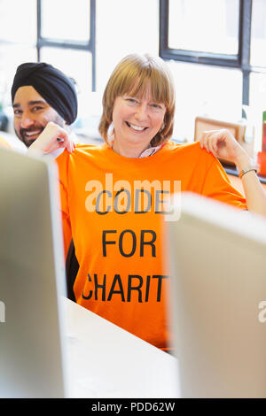 Portrait confident hacker wearing t-shirt, coding for charity at hackathon Stock Photo