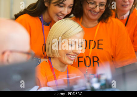 Hackers coding for charity at hackathon Stock Photo