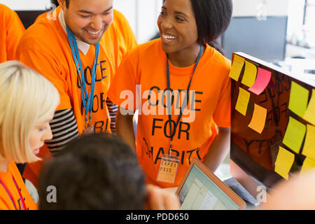Hackers coding for charity at hackathon Stock Photo
