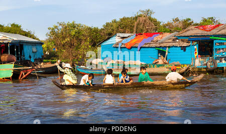 A Cambodian woman is transporting children from one house to another in floating village near Siem Reap, Cambodia Stock Photo