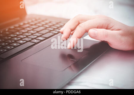female hand on a laptop, touchpad. work at the computer. notebooks Stock Photo