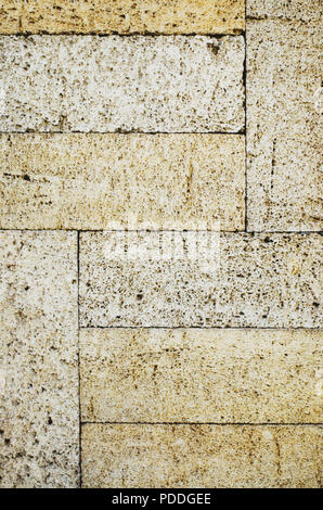 The texture of the stone wall. Stone in the section. Limestone. Granite. Marble. Coquina. Background. Stone floor. Pebbles. Macadam. Stock Photo