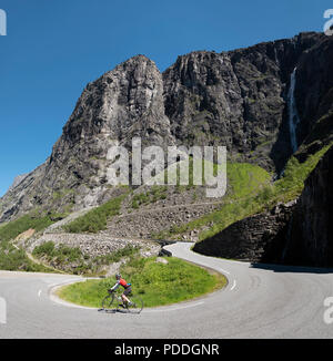 Female cyclist on a hairpin bend descending the famous Trollstigen pass, Norway Stock Photo