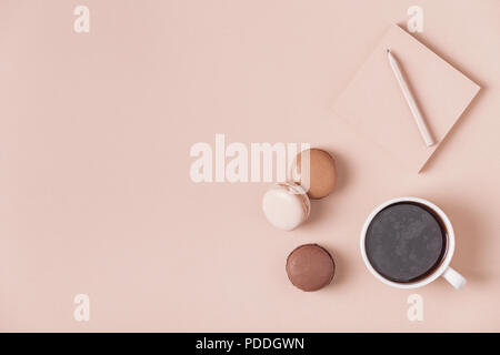 Cup of coffee with macaroons on pastel background, flat lay. Stock Photo