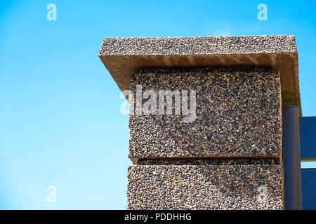 The texture of the stone fence with rectangular blocks, granite chips. Brown. Stock Photo