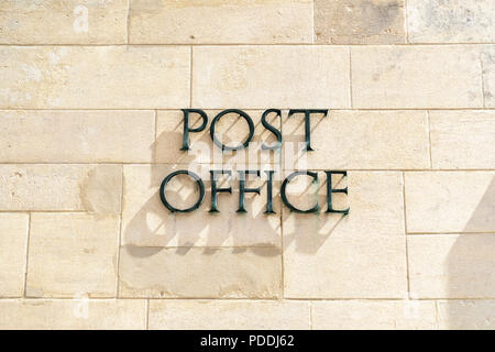 Post Office sign on stone wall Stock Photo