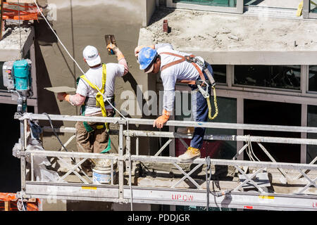Miami Beach Florida,Ocean Drive,man men male,laborer,under new construction site building builder,worker,workers,builder,helmet,scaffold,working,work, Stock Photo