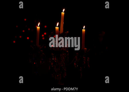Candles lit in retro candlestick in dark environment and black background Stock Photo
