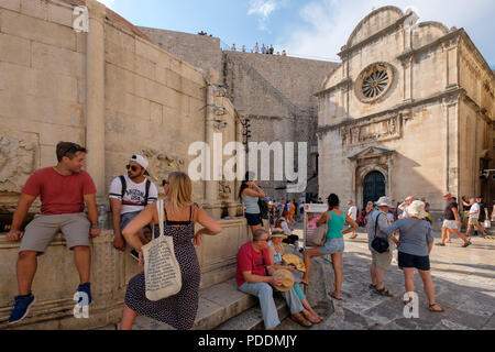 Tourists sitting on the Large Onofrio's Fountain in Dubrovnik, Croatia, Europe Stock Photo