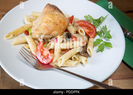 A plated meal of Pollo e Penne, Garlic infused roast Chicken thigh with Penne pasta and tomato, onion and mushroom