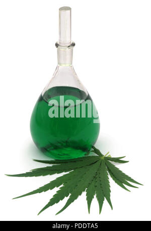 Cannabis leaves with green extract in glass jar as medicinal analyis Stock Photo