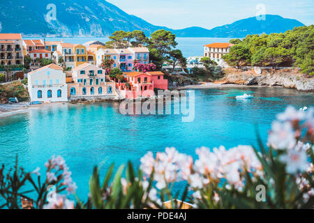 Turquoise colored bay in Mediterranean sea with beautiful colorful houses  in Assos village in Kefalonia, Greece. Town of Assos with colorful houses  on the mediterranean sea, Greece. Stock Photo