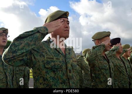 Soldiers assigned to the 6th Division, Singapore Army and 10th Singapore Infantry Brigade salute during playing of national anthems during the opening ceremony of Tiger Balm 18 at the 298th Regiment, Multi-Functional Training Unit (MFTU), Regional Training Institute (RTI), Waimanalo, Hawaii, on May 14, 2018. Tiger Balm is an annual bilateral military exercise designed to enhance the professional relationship, combat readiness, and interoperability between the US and Singapore, and fulfill and demonstrate regional security partnership and resolve. Stock Photo