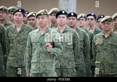 Soldiers assigned to the 6th Division, Singapore Army and 10th Singapore Infantry Brigade listening to opening remarks during the opening ceremony of Tiger Balm 18 at the 298th Regiment, Multi-Functional Training Unit (MFTU), Regional Training Institute (RTI), Waimanalo, Hawaii, on May 14, 2018. Tiger Balm is an annual bilateral military exercise designed to enhance the professional relationship, combat readiness, and interoperability between the US and Singapore, and fulfill and demonstrate regional security partnership and resolve. Stock Photo