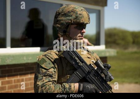 U.S. Marine Corps SSgt. Matthew Tarkey, chief foreign weapons instructor, Marksmanship Training Company, Weapons Training Battalion, waits for instructions during the Royal Marine Operational Shooting Competiton (RMOSC) at Altcar Training Camp, Hightown, United Kingdom, May 14, 2018. The U.S. Marine Corps travels to the United Kingdom annually to compete in the (RMOSC) with the opportunity to exchange operational experiences, physical and marksmanship training. Stock Photo