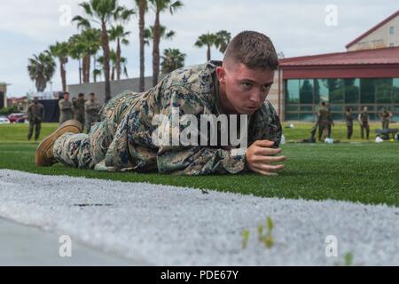 Lance Cpl. Corey Holladay, warfare simulation system operator, Training Support Division, Headquarters and Support Battalion, low crawls as a part of the maneuver under fire during a combat fitness test for the commanding general’s inspection program at Page Field House on Marine Corps Base Camp Pendleton, Calif., May 15, 2018. The purpose of the CFT is to assess a Marine's physical capacity in a broad spectrum of combat related tasks. Stock Photo