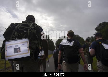 Members of the Office of Special Investigations carry dedicated rucksacks during a ruck march as part of Police Week, May 18, 2018, at Seymour Johnson Air Force Base, North Carolina. The team was marching for several special agents who were killed in the line of duty, including Maj. Adrianna Vorderbruggen, who was one of six troops killed by a suicide bomber in Afghanistan in 2015. Stock Photo