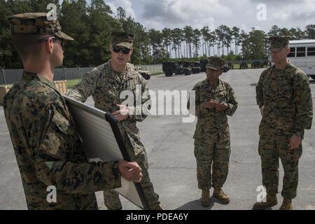 U.S. Marine Corps 1st Lt. Jacob Hoxie with 2nd Supply Battalion, Combat Logistics Regiment 25, 2nd Marine Logistics Group, explains maritime prepositioning force operations to Col. Boyd Miller, commanding officer of Headquarters Regiment, 2nd MLG, during Command Post Exercise 2-18 on Camp Lejeune, N.C., May 19, 2018. 2nd MLG conducted CPX 2-18 in order to improve its warfighting readiness in command and control of the Logistics Combat Element for II Marine Expeditionary Force. Stock Photo