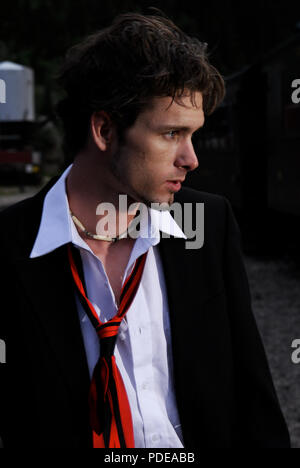 A disheveled man in an old narrow guage trainyard.  Unique, exclusive, people stock photos. Stock Photo