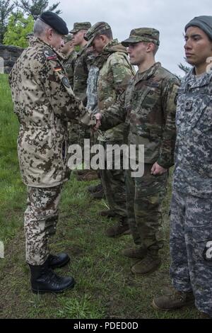 U.S. Army Spc. Benjamin Wilke, an infantryman assigned to Headquarters Company, 1-102nd Infantry Battalion, Connecticut Army National Guard, receives the German Armed Forces Proficiency Badge (GAFPB) from German Army Lt. Col. Michael Breuer, the German liaison officer to the United States Military Academy, during the Region 1 Best Warrior Competition at West Point, N.Y., May 19, 2018. The competition, held May 16-19, 2018, is an annual event in which junior enlisted Soldiers and noncommissioned officers (NCOs) from eight Northeastern states compete in several events intended to test their mili Stock Photo