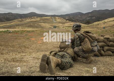 U.S. Marine Corps Sgt. Kathrine E. Cleary, right, combat instructor, School of Infantry (SOI)-West, monitors a Marine Combat Training (MCT) student's line of fire on a rifle range at the Marine Corps SOI-West, Camp Pendleton, Calif., May 18, 2018. MCT gives Marines with Military Occupational Specialties other than Infantry (03xx) a basic understanding of the Marine Corps' warfighting ethos, core values, basic tenets of maneuver warfare, leadership responsibilities, mental, moral, and physical resiliency in order to contribute to the successful accomplishment of their unit's mission. Stock Photo