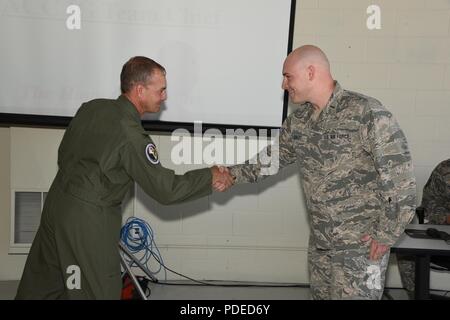 U.S. Air Force Col. Troy Henderson, the Air Combat Command (ACC) inspector general team chief, left, shakes hands and presents the prestigious inspector general’s coin to 2nd Lt. Michael Schuldt, of the 119th Logistics Readiness Squadron, for Schuldt’s exceptional performance during a unit effectiveness inspection (UEI) at the North Dakota Air National Guard Base, Fargo, N.D., May 20, 2018. The inspector general’s coin is a rare honor, given to only .5% of the Airmen being inspected. A group of unit effectiveness inspection (UEI) team members is evaluating the 119th Wing at the North Dakota Ai Stock Photo