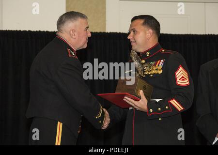 The Assistant Commandant of the Marine Corps Gen. Glenn M. Walters, left, presents the Jack W. Demmond Award for Aviation ground Marine of the year to Gunnery Sgt. Jonathon E. Thornton, logistics chief, Marine Wing Support Squadron 372 (MWSS-372), Marine Aircraft Group 39 (MAG-39), during the 47th annual Marine Corps Aviation Association (MCAA) Symposium and Awards Banquet, San Diego, Calif., May 18, 2018. Walters was the guest speaker for the event and presented 13 unit awards and 16 individual awards during the ceremony. Stock Photo