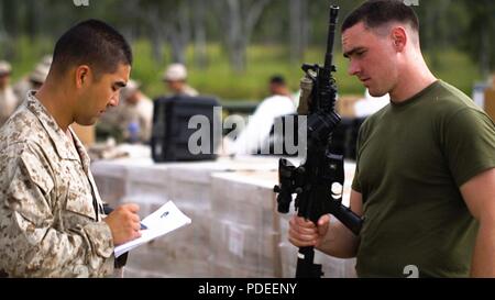 1st Lieutenant Ryan Sohm, Weapons Platoon Commander checks the rifle serial number of LCpl. Francis Hollahan that he will use for Marine Rotational Force Darwin (MRF-D) on Shoal Water Bay Training Area, Australia, May 13, 2018. MRF-D was established by former U.S. President Barack Obama and former Australian Prime Minister Julia Gillard in 2011 to build and strengthen partnerships in the Pacific region. Approximately 1,500 Marines are scheduled to participate in training events around the country. Stock Photo