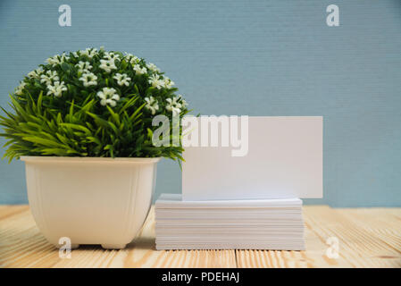 Blank business cards and little decorative tree in white vase on wooden working table with copy space for add text ID. and logo, business company conc Stock Photo