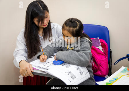 Teacher and student problem solving in classroom. Stock Photo