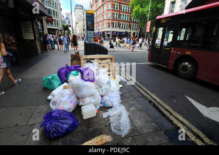 London, England, UK. Rubbish bags piled up by a bin in central London Stock Photo