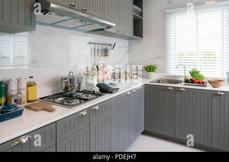 Kitchen wood utensils, chef accessories. Hanging copper kitchen with white tiles wall. Stock Photo