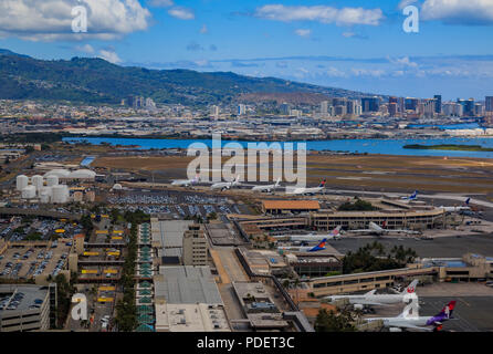 Honolulu, Hawaii, USA - May 25, 2015: Aerial view of downtown Honolulu and airplanes parked on the field of Daniel K. Inouye International Airport HNL Stock Photo