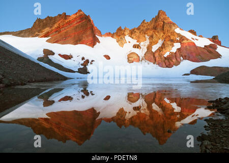 Pre dawn civil twilight glow on Central Oregon’s Broken Top reflecting into Bend Glacier Lake. Stock Photo