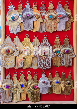 Ethnic handmade jewelry representing Hamsa or Hand of Fatima symbol at the market or souk in Fes, Morocco Stock Photo