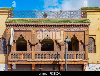 Ornate wood carved balcony and ironwork on the facade of a Moroccan riad in Marrakech, Morocco Stock Photo