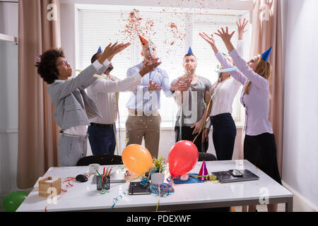 Group Of Young Businesspeople Celebrating New Year Party In Office Stock Photo