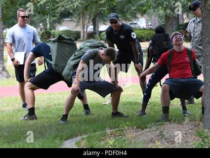 Members of the 81st Communications Squadron team participate in partner squats during the 81st Security Forces Squadron 5K Fallen Defender Ruck and Obstacle Course competition at the Crotwell Track at Keesler Air Force Base, Mississippi, May 15, 2018. The event was held during National Police Week, which recognizes the service of law enforcement men and women who put their lives at risk every day. Stock Photo