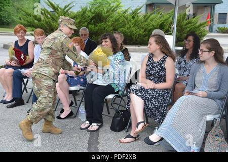 Mrs. Lori Joseph, the wife of Col. John Joseph, incoming 1st Brigade commander, is presented with of a bouquet of yellow roses welcoming her and the Joseph family to brigade during the 1st Brigade (Quartermaster) Change of Command ceremony held at the Maj. Gen. Charles C. Rogers U.S. Army Reserve Center in Charleston, WV on 19 May 2018. Stock Photo