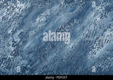 Grunge blue uneven old aged daub plaster wall texture background with stains and paint strokes, close up