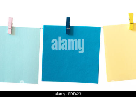 pieces of note paper pegged to a string on white background macro Stock Photo