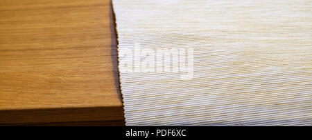 Folded grey cotton napkin isolated on wood table top view background Stock Photo