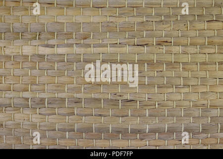A woven Mat of reeds. The texture of dry cane. Dark yellow. Stock Photo