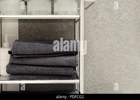 Folded towels, carpet Slippers and bathrobes on the shelf of the wardrobe in the hotel. Bathroom accessories Stock Photo