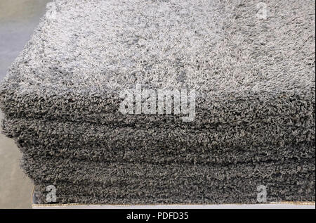 Stack gray bath mats bath mats Stack, stacked on top of each other. Terry mats. Stock Photo