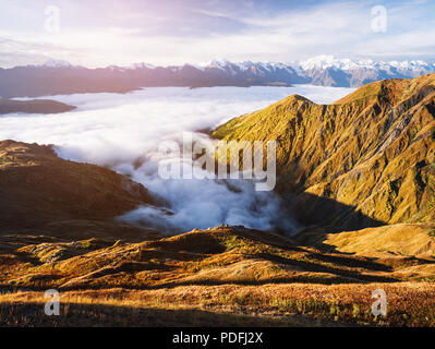 Autumn landscape in the mountains. Morning fog. Sunlight on the slopes. Tops in snow. Caucasus, Georgia, Zemo Svaneti Stock Photo