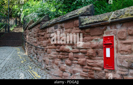 A traditional British postbox mounted in a red stone wall. With copy space. Stock Photo