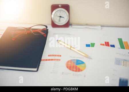 Business concept of office working and analysis graphics and clock on table Stock Photo