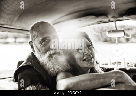 Portrait of a senior hipster couple inside their vintage van  Stock Photo